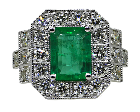 Emerald and diamond ring on a white background